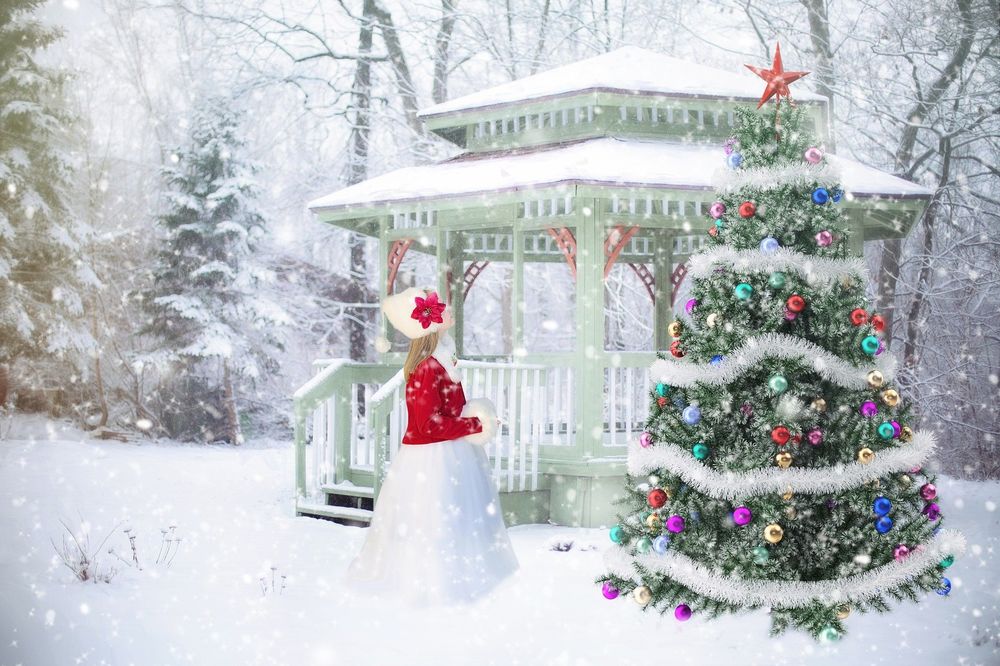 Обои для рабочего стола Девочка стоит перед новогодней елкой в парке перед беседкой елочкой