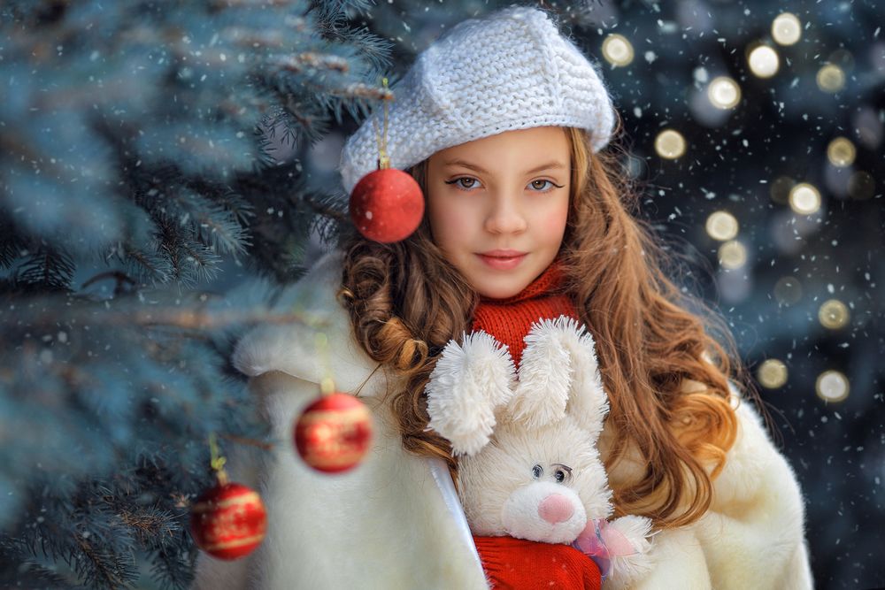 Обои для рабочего стола Девочка в берете с игрушечным зайкой стоит у елки. Фотограф Георгий Бондаренко