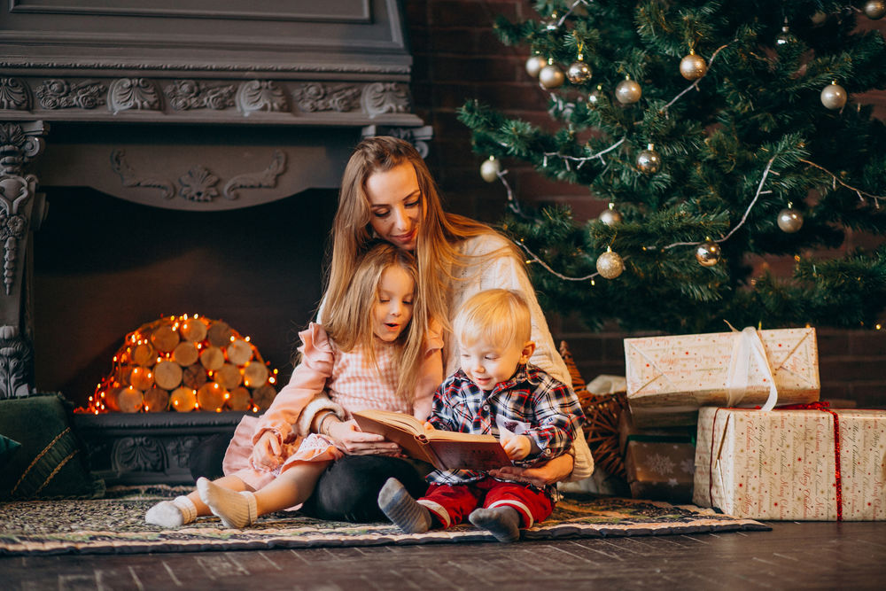 Обои для рабочего стола Мама с детками сидит на полу в комнате с новогодней елкой