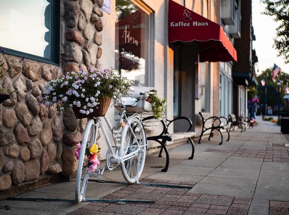 Обои для рабочего стола Корзина с цветами на велосипеде стоит у дома