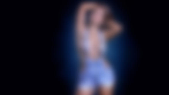 Обои на рабочий стол Девушка с поднятыми за голову руками в джинсовой одежде на темном фоне