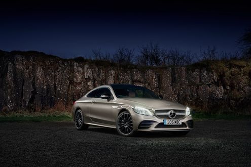 Обои на рабочий стол Серебристый Mercedes-Benz AMG C43 4Matic Coupe стоит ночью у горного образования