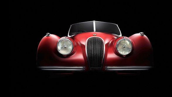 Обои на рабочий стол Проекция красного ретро-автомобиля Jaguar XK 1950 на черном фоне