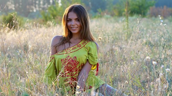 Обои на рабочий стол Улыбающаяся девушка стоит в траве, фотограф Adina Voicu