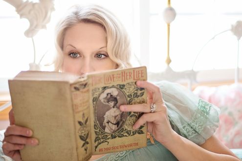 Обои на рабочий стол Блондинка с серыми глазами читает книгу на размытом фоне комнаты, by JillWellington