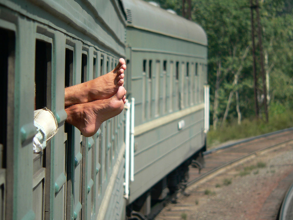 Девочка с грустью смотрит в окно вагона поезда