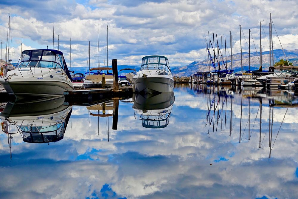 Обои для рабочего стола Отражение в воде озера неба с облаками, на фоне катеров и лодок, by Siggy Nowak