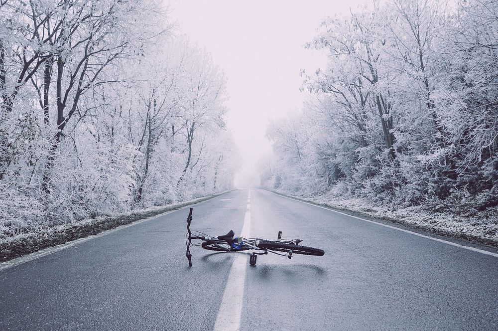 Обои для рабочего стола Велосипед лежит на дороге на фоне заснеженных деревьев по обочине дороги, by Pexels