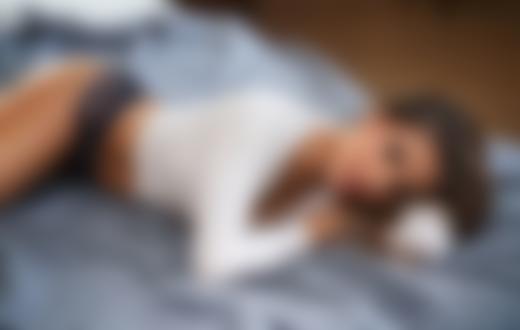 Обои на рабочий стол Девушка Sharina в белой кофточке и в кружевных трусиках лежит на кровати, фотограф Maarten Quaadvliet