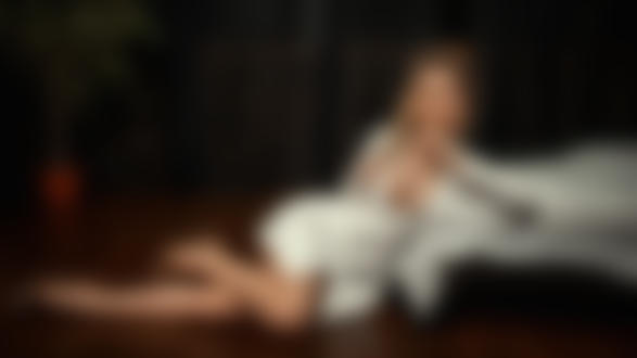 Обои на рабочий стол Девушка с оголенной грудью сидит на полу у кровати