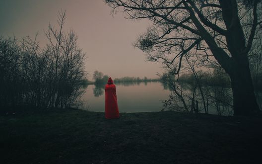 Обои на рабочий стол Девушка в красном плаще стоит на берегу озера, фотограф Fan D