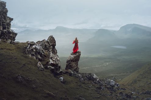 Обои на рабочий стол Девушка в длинном красном платье стоит на скале, by Lizzy Gadd