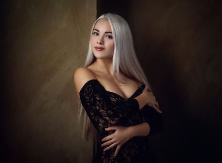 Обои на рабочий стол Девушка - блондинка в черном платье стоит у стены. Фотограф Сергей Сорокин