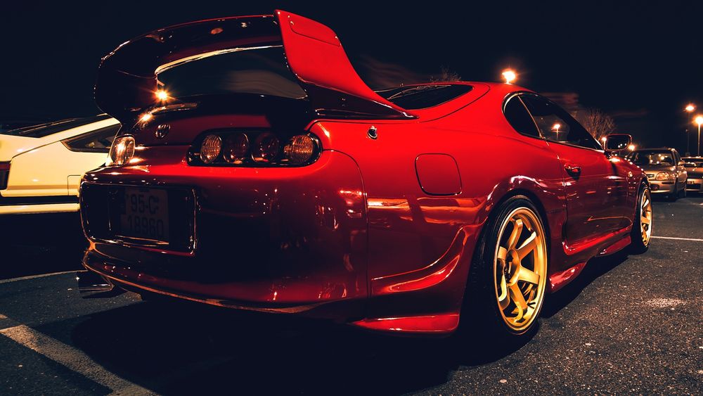Обои для рабочего стола Красная Toyota Supra стоит на стоянке в ночи