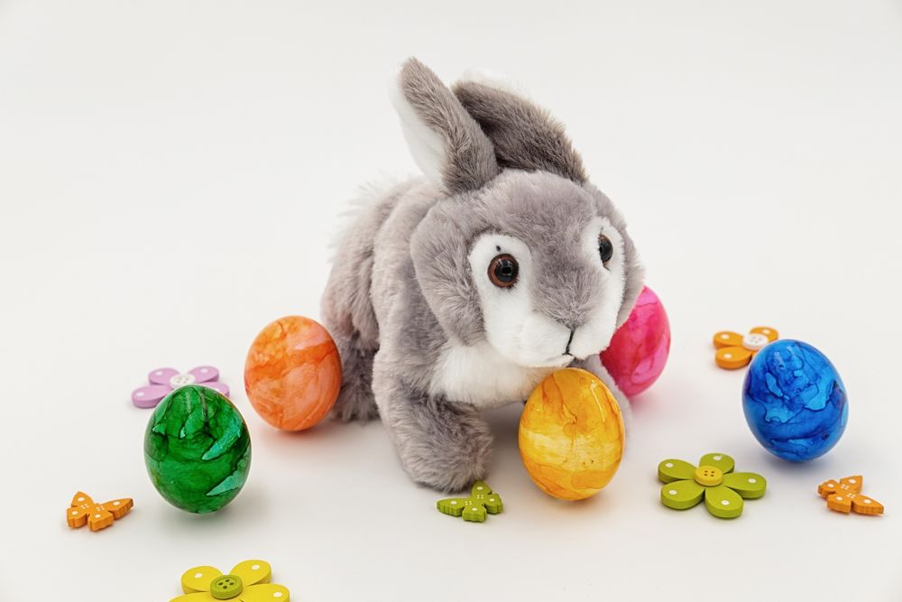 Обои для рабочего стола Игрушечный кролик на фоне разноцветных пасхальных яиц и фигурок в виде бабочек и цветов, by Bruno