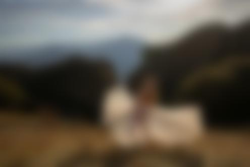 Обои на рабочий стол Полуобнаженная девушка в белой юбке стоит на фоне гор. Фотограф Леонид Мочульский