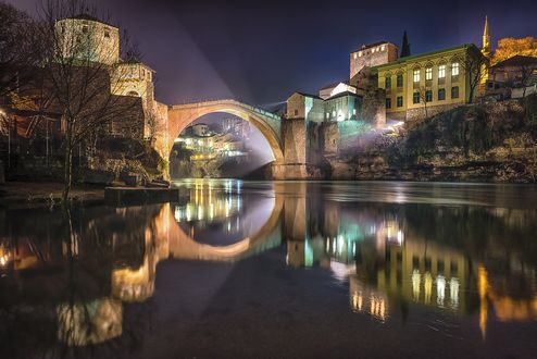 Обои на рабочий стол Старый мост - это османский мост 16-го века в городе Mostar in Bosnia and Herzegovina / Мостар в Боснии и Герцеговине, который пересекает реку Neretva / Неретва и соединяет две части города, фотограф Dzenad Dzino