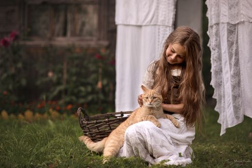 Обои на рабочий стол Девочка с рыжей кошкой сидит на трве, фотограф Мария Илмаз