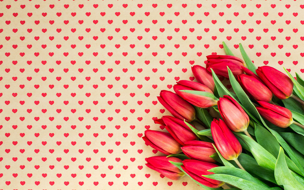 Обои для рабочего стола Букет красных тюльпанов на фоне с сердечками