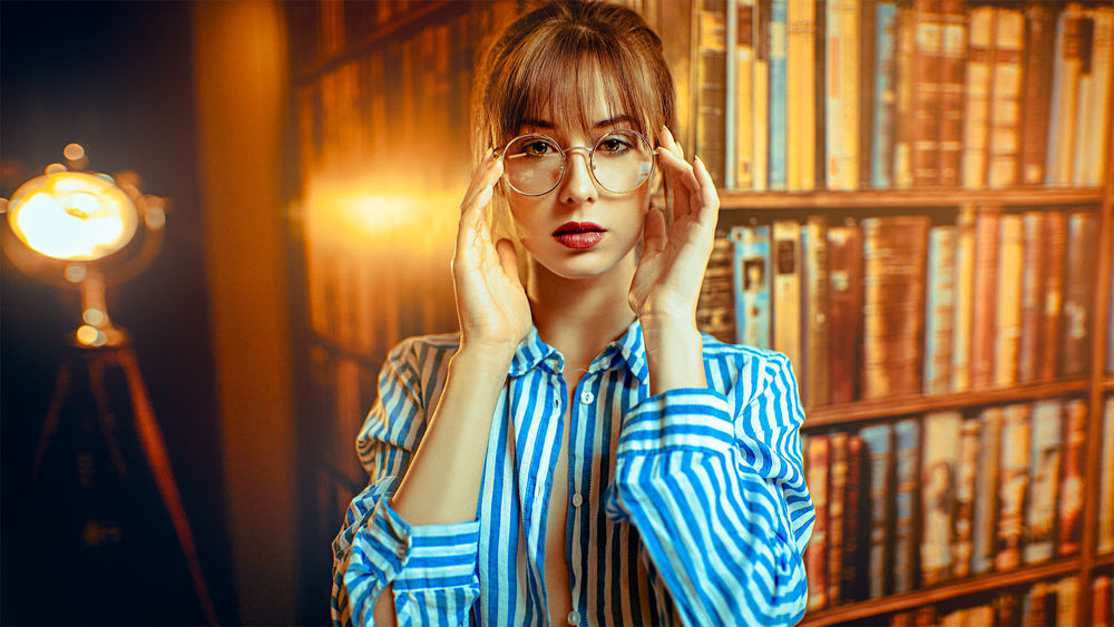 Обои для рабочего стола Модель Диана в очках стоит в библиотеке. Фотограф John Noe