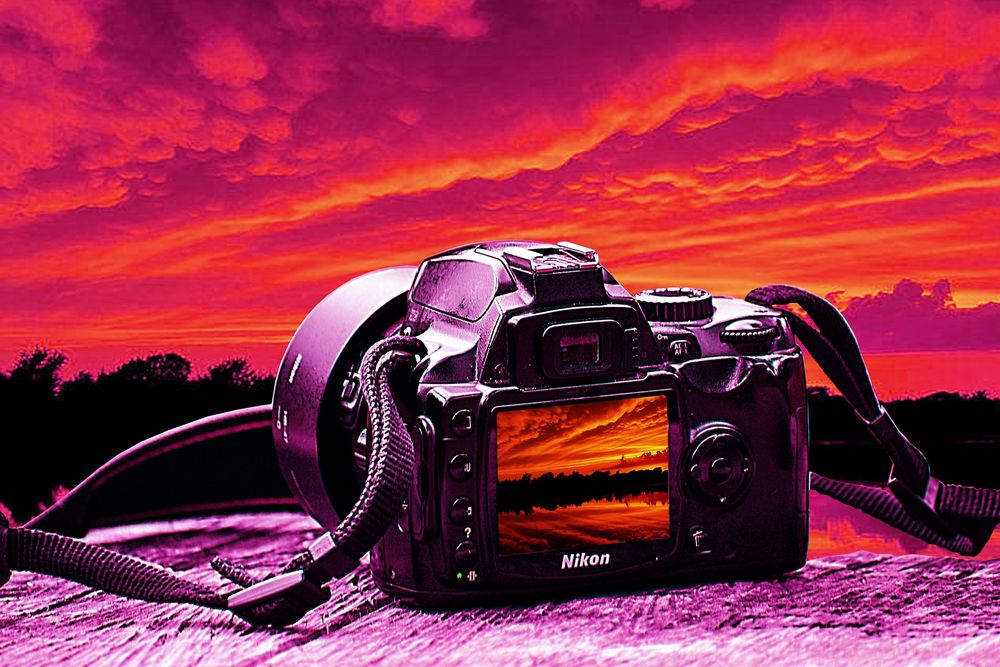 Обои для рабочего стола Видеокамера Никон на фоне неба в закате солнца, by fernando zhiminaicela