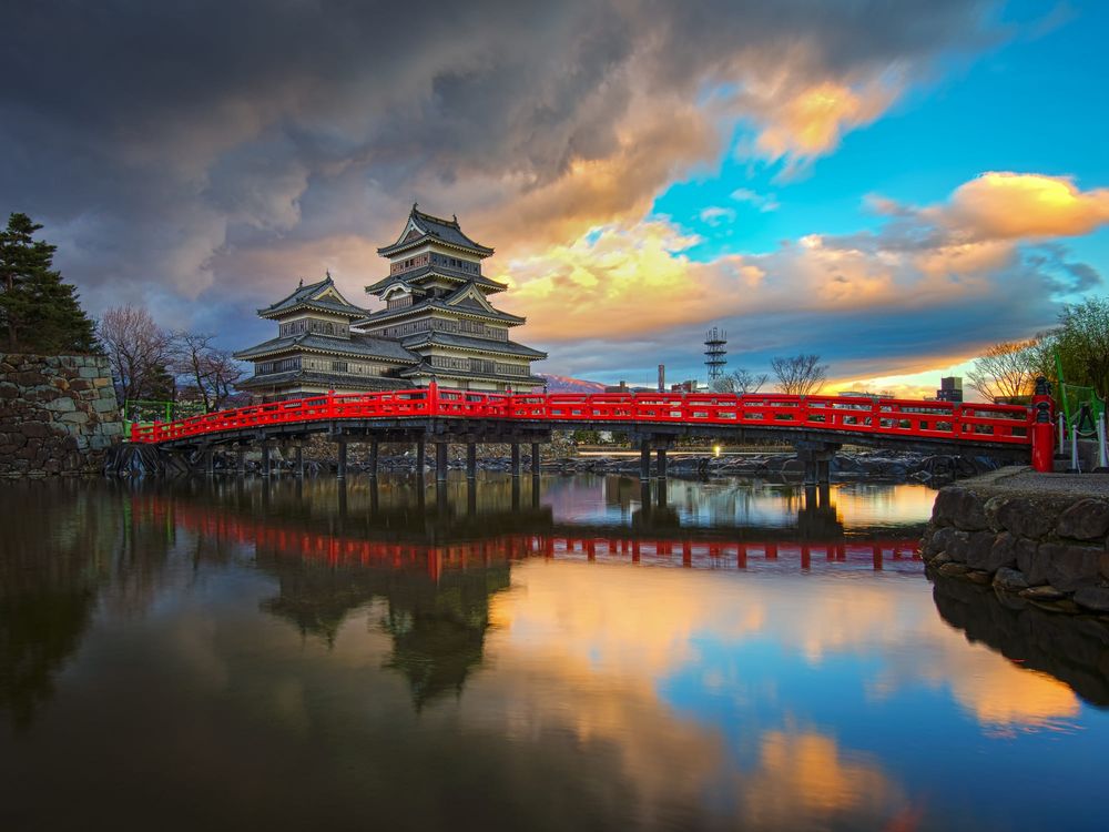 Обои для рабочего стола Matsumoto castle / Замок Мацумото / Замок Ворона с красным мостом, отражающийся в воде, префектура Нагано, Япония / Japan, автор Phattana Stock