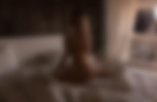 Обои для рабочего стола Обнаженная девушка с длинными волосами стоит на коленях на кровати в комнате на фоне окна