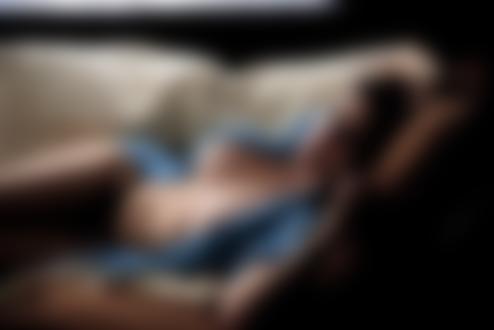 Обои на рабочий стол Брюнетка в расстегнутой кофточке и в черных трусиках лежит на диване