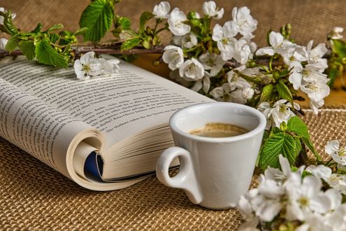 Обои на рабочий стол Чашка кофе стоит рядом с книгой и весенними цветущими веточками вишни, by Anrita