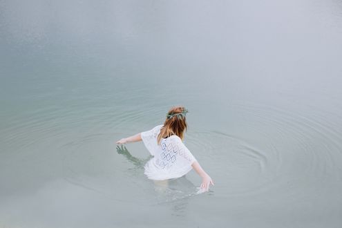 Обои на рабочий стол Девушка с венком на голове стоит в воде