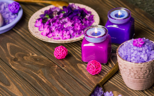 Обои на рабочий стол Spa-набор: две свечи в баночках, цветки фиалок в тарелке и морская соль на деревянной поверхности