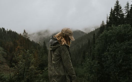 Обои на рабочий стол Девушка на фоне гор, склоны которых покрыты елями, фотограф Katie Drazdauskaite