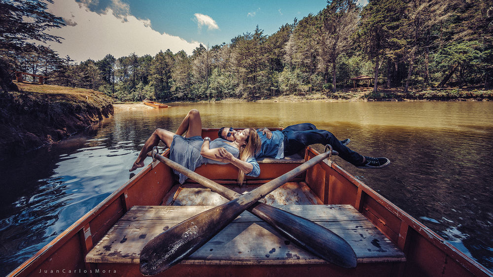 Обои для рабочего стола Парень с девушкой лежат в лодке, by Juan Carlos Mora