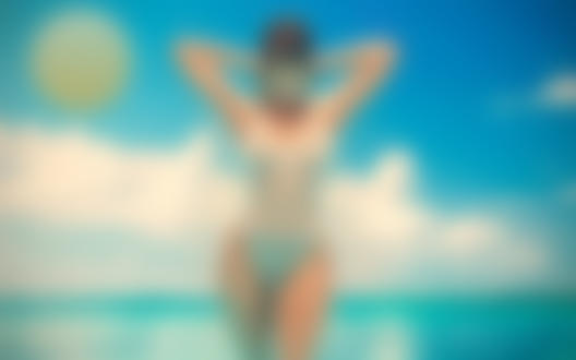 Обои для рабочего стола Девушка в купальнике стоит на фоне неба и моря