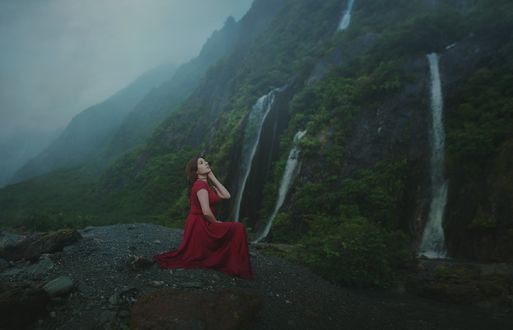 Обои на рабочий стол Девушка в длинном платье сидит на фоне водопадов, фотограф Alex Benetel
