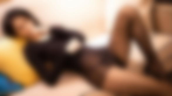 Обои для рабочего стола Девушка азиатской внешности лежит на диване