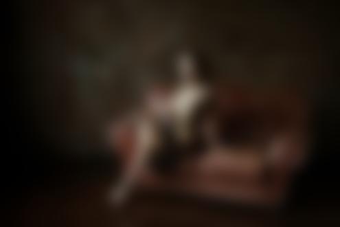 Обои на рабочий стол Девушка в прозрачном платье сидит на диване. Фотограф Стефанович Владимир