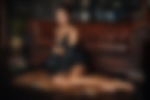 Обои для рабочего стола Девушка сидит на шкуре на полу у дивана, фотограф Dmitry Arhar