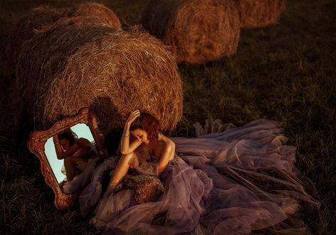 Обои на рабочий стол Девушка сидит на земле перед зеркалом у валуна сена, by Nikolay Tikhomirov