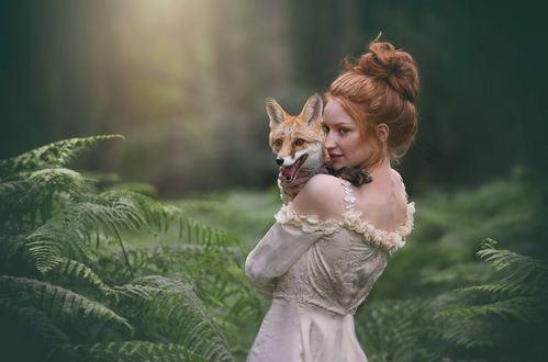 Обои на рабочий стол Девушка с лисой на руках стоит среди папоротника, фотограф Miss Froggi