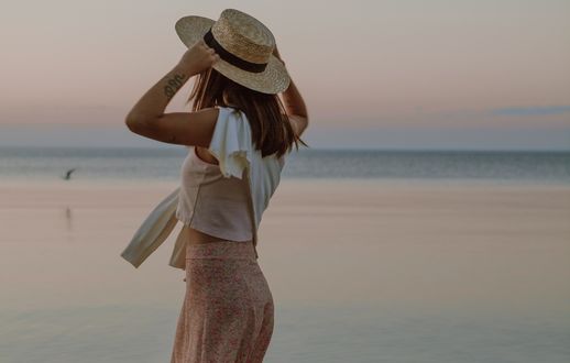 Обои на рабочий стол Девушка в шляпе стоит на фоне моря, by Jasmin Chew