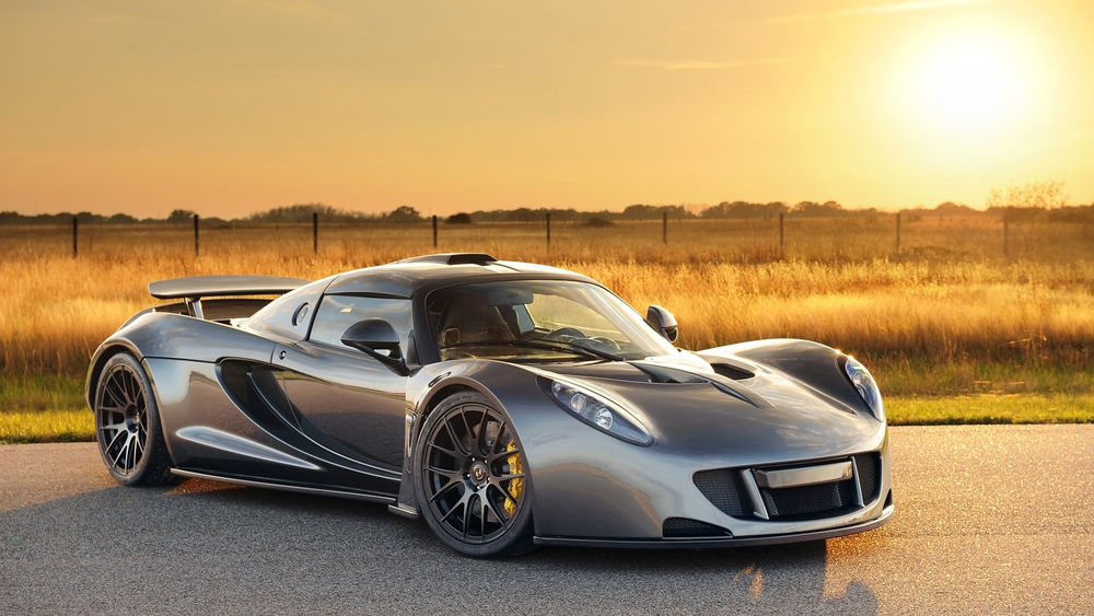 Обои для рабочего стола Henneseey Venom GT стоит в поле на закате солнца