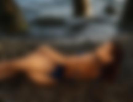 Обои на рабочий стол Девушка в купальнике лежит у моря
