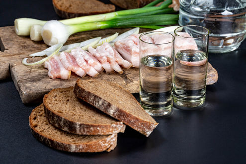 Обои на рабочий стол Доска с закуской и рюмками с водкой