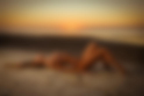Обои для рабочего стола Девушка Лиза лежит на песке на фоне заката. Фотограф Sergey Gokk