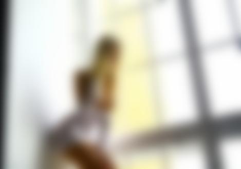 Обои для рабочего стола Блондинка Мария Лапулина в приспущенном белом кружевном платье с обнаженной грудью стоит у стены в помещении на фоне окна, фотограф Stakis Laus