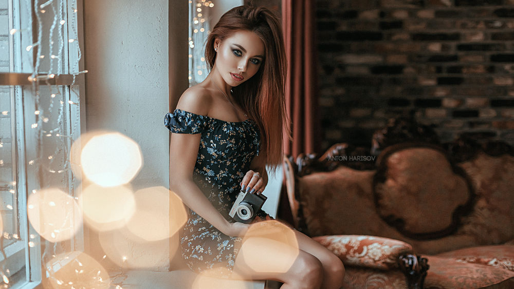 Обои для рабочего стола Модель Алиса с фотоаппаратом в руке сидит у окна. Фотограф Харисов Антон