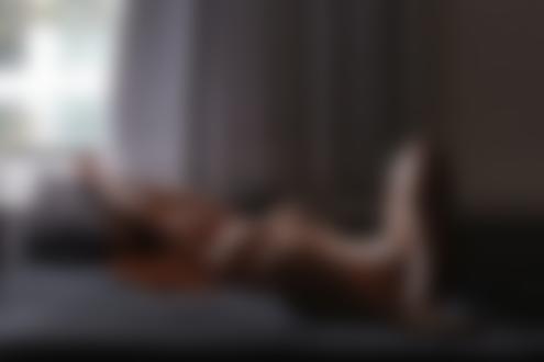 Обои для рабочего стола Рыжеволосая девушка Raquel Duarte / Ракель Дуарте в белых трусиках топлес лежит на кровати в комнате на фоне окна