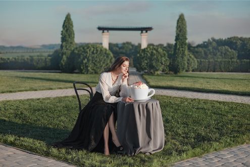 Обои на рабочий стол Девушка сидит на стуле за столиком на природе с большой кружкой десерта, фотограф Кисляк Анастасия