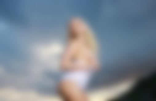 Обои на рабочий стол Украинская эротическая фотомодель Liza B / Елизавета Воронина стоит в белой майке на фоне пасмурного неба